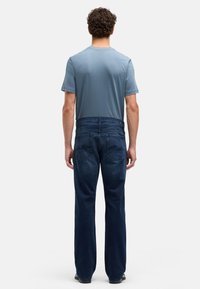 Niebieski t-shirt z okrągłym dekoltem, zestawiony z ciemnoniebieskimi, prostymi dżinsami, charakteryzujący się klasycznym wzorem z pięcioma kieszeniami i gładką fakturą.