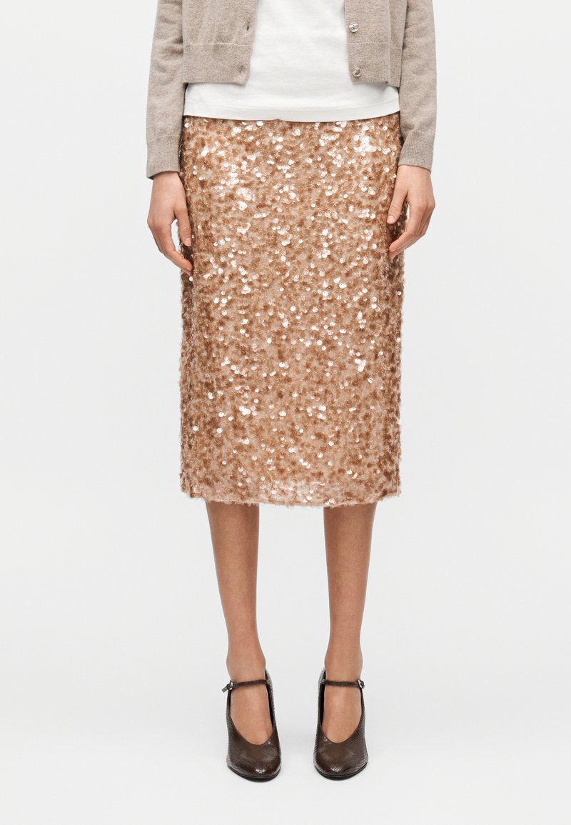 Midi φούστα με παγιέτες σε ροζ χρυσό, εφαρμοστή γραμμή, λαμπερή υφή και ομαλή φόδρα, συνδυασμένη με σκοτεινά πέδιλα με λουράκι αστραγάλου.