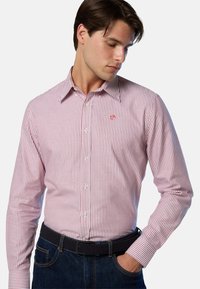 Camisa de manga larga a rayas rojas y blancas en una mezcla de algodón, con cuello abotonado y logotipo bordado en el pecho.