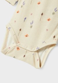 Kurze Ärmel Baby-Body aus hellbeigem Rippstoff mit kleinen Blumenmustern in Orange, Lila und Grün. Druckknopfverschluss am Boden.