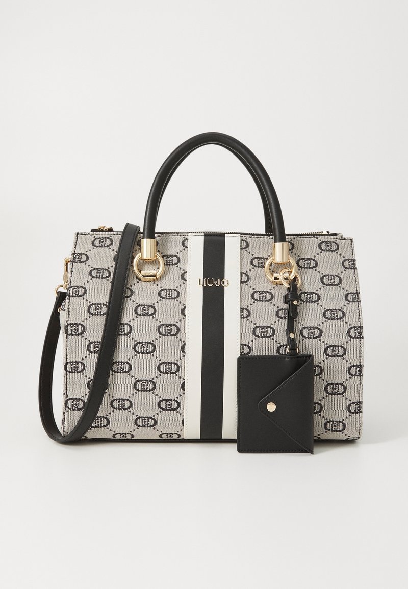 Sac à main beige et noir à motifs avec poignées noires, rayures verticales blanches et noires, accents dorés et petite pochette noire attachée.