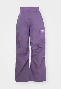 Purple wide-leg cargo pants with multiple pockets, high waist, and a white Nike logo on the right thigh pocket.