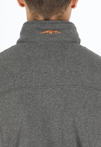 Gray fleece pullover with a high collar. Features a small orange logo embroidered on the back. Soft texture, no visible fastenings.