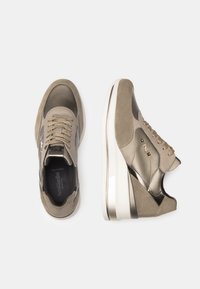 Sneaker mit einem metallischen Taupe-Obermaterial, strukturierten Wildlederelementen und einer weißen Plateausohle. Mit beigen Schnürsenkeln und einer seitlichen Markenverzierung.