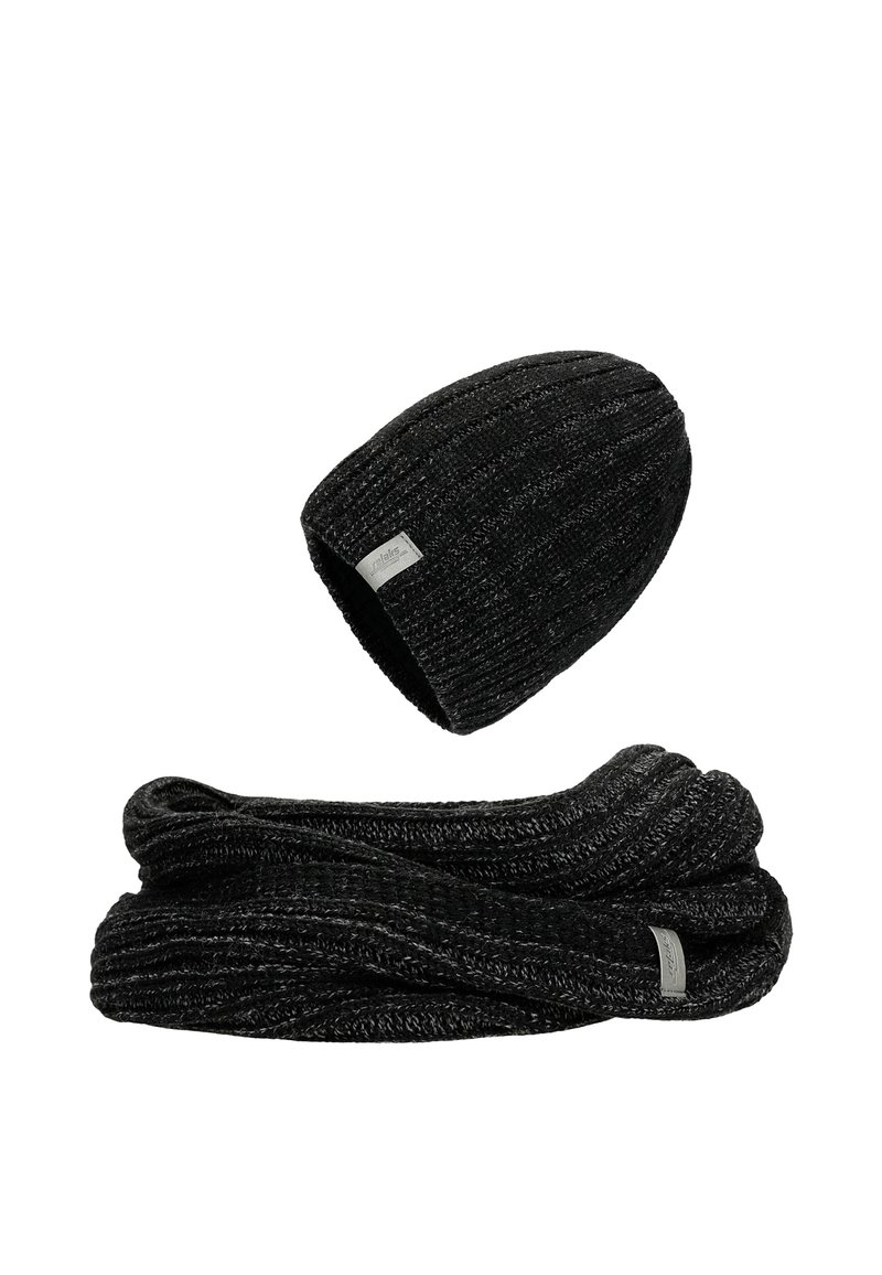 Zwarte gebreide beanie met ribbelpatroon en klein label, gecombineerd met een bijpassende ribbel sjaal, beide gemaakt van zachte, gestructureerde stof.