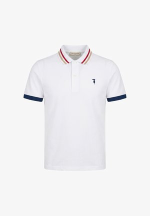 Polo blanc à manches courtes avec poignets de manches bleu marine, col rayé beige et rouge, et petit logo bleu marine sur la poitrine gauche.