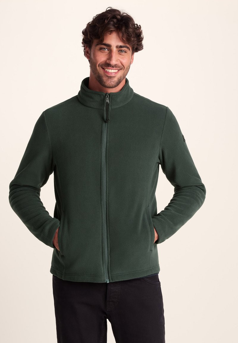 Dark green fleece jacket with a high collar, full zip front, and side pockets. Smooth texture and fitted design with ribbed cuffs.