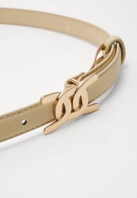 Cintura in pelle beige con fibbia doppia in tonalità oro, texture liscia e cuciture sottili lungo i bordi. Vestibilità regolabile con fori.