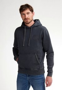 Felpa con cappuccio grigio carbone con tasca frontale, coulisse regolabile e dettaglio logo testurizzato sul petto. Vestibilità ampia, materiale misto cotone.