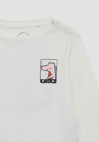 Witte lange mouwen shirt van katoen met een kleurrijke cartoon krokodil-afbeelding en de tekst "CROCO" aan de onderkant. Twee drukknoopjes op de schouder.