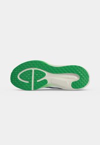 Schoenzool met groene profiel op hiel- en voorvoetgebieden en witte tussenzool met getextureerd grip patroon op een effen achtergrond.