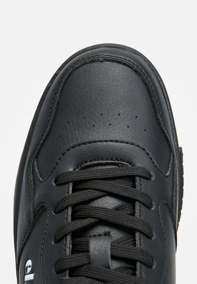 Baskets en cuir noir avec une surface texturée, bout arrondi, lacets noirs et petites perforations pour la ventilation. Comprend un marquage latéral.