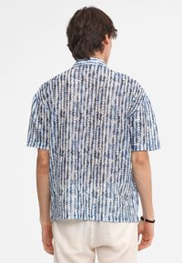 Korte mouw knoopshirt in een lichtgewicht stof, met een blauw-witte gestreepte patroon, voorzien van een ontspannen pasvorm en een afgeronde zoom.