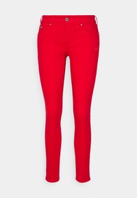 Jeans ajustados rojos con una textura suave, diseño clásico de cinco bolsillos, lazos para cinturón y cierre frontal con botón y cremallera.