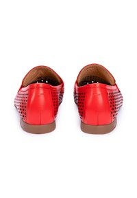 Scarpe di pelle rossa con design perforato, suola marrone e superficie liscia. La vista posteriore mostra la forma arrotondata e la morbida fodera.