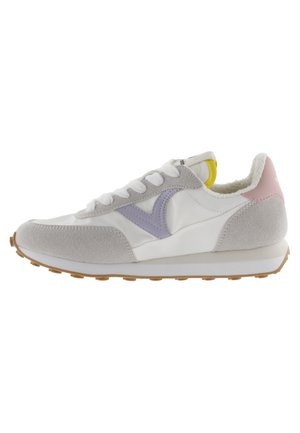 Zapatillas blancas y grises con materiales de ante y sintéticos, acentos morados y una suela de goma texturizada. Presenta un cuello acolchado y un diseño de cordones.