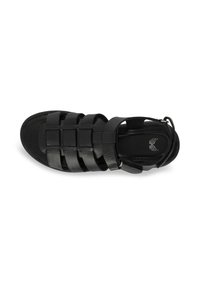 Black leather sandal featuring woven strap design, open heel, rounded toe, and cushioned insole. Adjustable ankle strap with metallic hardware.