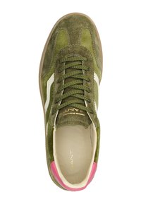 Sneaker verde in camoscio con accenti bianchi, punta tonda e dettaglio in rosa sul tallone. Presenta lacci piatti e branding all'interno della scarpa.