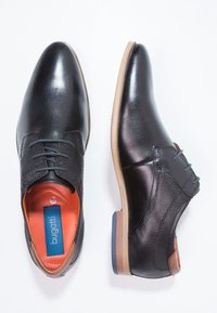 Chaussures noires en cuir lisse avec un dessus en cuir et des détails en maille texturée. Présente des accents marron, un petit talon et un design à lacets.