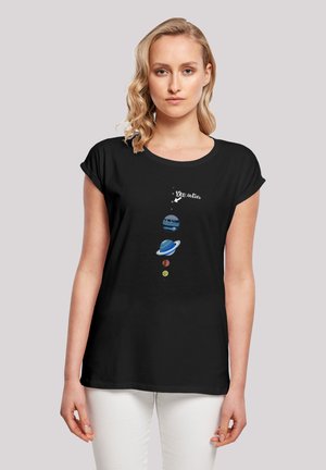 Black cotton t-shirt with short sleeves, featuring a colorful planetary graphic and the text "You Are Here" above the solar system design.
