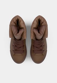 Brune høye sneakers med polstret krage, teksturerte lisser og en glatt gummisåle, med en ensartet farge og minimalistisk design.