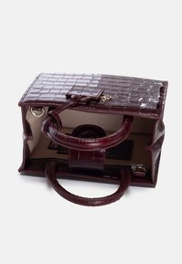 Borsa bordeaux con texture a coccodrillo, forma strutturata, doppi manici e chiusura a scatto sicura. Interno foderato in beige.