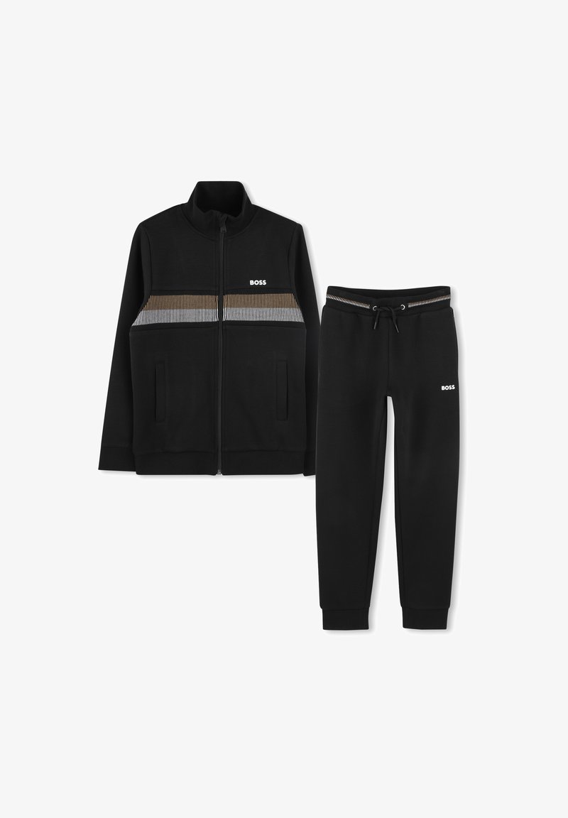 Svart zip-up jakke med et fargeblokkert brystdesign i brunt og stripete accenter; matchende svarte joggebukser med strikk i midjen. Hvit merkevare er synlig.