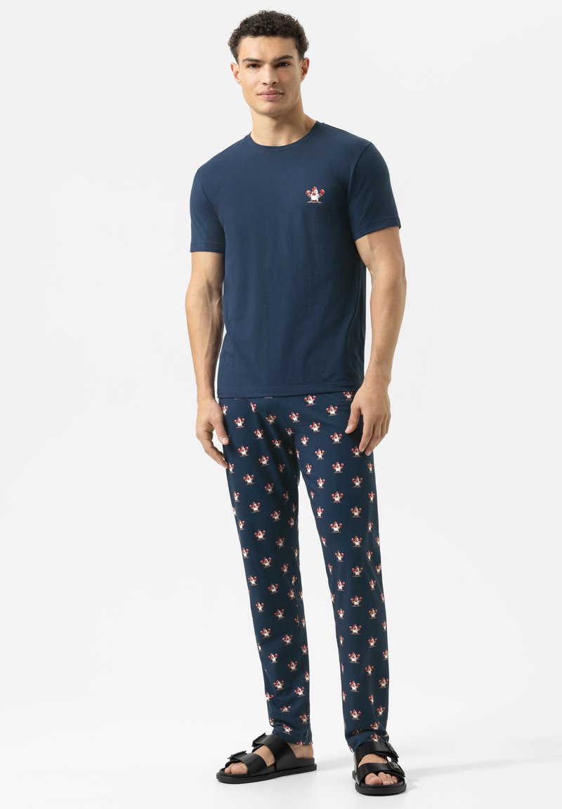 Marine katoen T-shirt met een kleine kreeftgrafiek, gecombineerd met marine pyjamabroeken met een kreeftenpatroon, gedragen met zwarte sandaal.