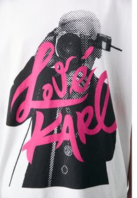 Fehér pamut póló, fekete és rózsaszín grafikával. A szöveg "Lové KARL" feliratú, pöttyös mintával, sziluett formában.