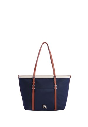 Bolsa tote azul marino con ribete crema y correas de hombro ajustables marrones, con el logo plateado DA en el bolsillo delantero.