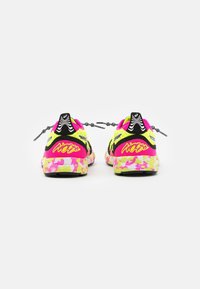 Baskets néon jaunes et roses vives avec un motif camouflage, des accents noirs et des lacets élastiques. Présente une semelle rembourrée pour plus de confort.