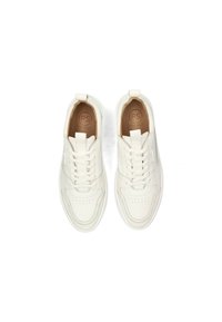Zapatillas de cuero blancas con una textura suave, que presentan una puntera redondeada, cordones y una tira en el talón para facilitar su uso.