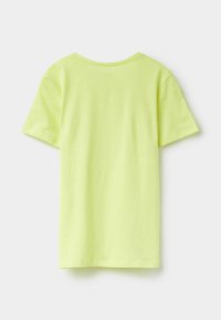 T-shirt z krótkim rękawem w jaskrawym zielono-limonkowym kolorze, wykonany z bawełny. Gładka faktura, okrągły dekolt i prosty dół. Brak widocznych wzorów lub akcentów.