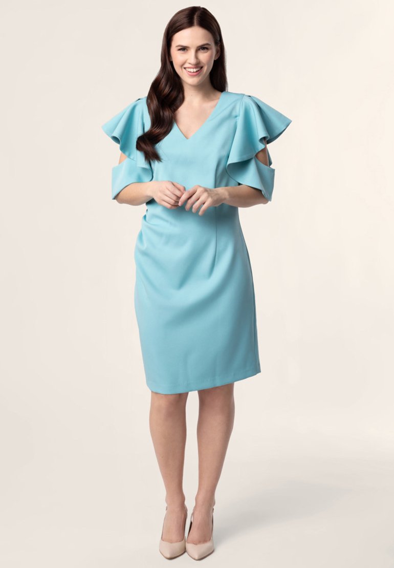Une robe bleu clair avec un décolleté en V, des manches flottantes et un devant plissé. Tissu lisse, design midi, assortie à des talons nus.