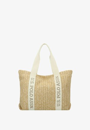 Sac fourre-tout tissé beige avec de larges poignées crème portant le texte « U.S. POLO ASSN. » inscrit verticalement le long de chaque sangle.