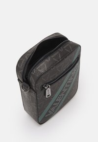 Sac à motifs gris avec une fermeture éclair à l'avant et une bande d'accent turquoise. Comprend des accessoires en argent et une étiquette "VALENTINO" bien en vue sur le devant.