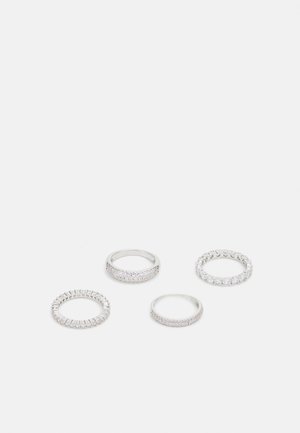 Set de patru inele din argint, fiecare având texturi și designuri diferite: două cu cristale pavé și baguette, un band neted și unul cu pietre rotunde.