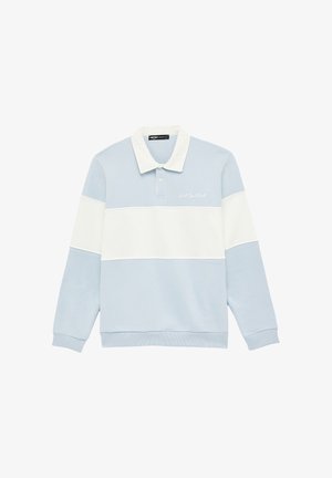 Polo de manga larga azul claro con una franja horizontal blanca a lo largo del pecho y los brazos, cuello blanco y pequeño texto bordado en blanco en el pecho.