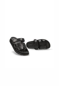 Chanclas negras de slides con dos correas anchas de cuero suave, plantilla texturizada y suela de goma gruesa. Diseño moderno y abierto.