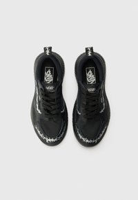 Sneaker Vans neri con una parte superiore in tessuto texturizzato, accenti argento a contrasto e un motivo unico di filo spinato sui lati.