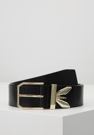 Zwarte leren riem met goudkleurige rechthoekige gesp en decoratief goudkleurig metalen detail gegraveerd met "Patrizia Pepe" op een wit oppervlak.