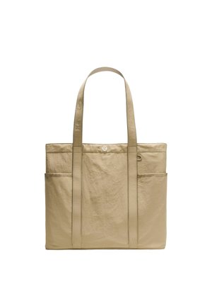 Beige mulepose med to lange håndtag, forlommer og lille metal logo centreret nær øverste kant.