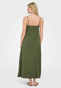 Robe maxi vert olive avec des bretelles fines, design fluide et fermeture éclair au dos. Tissu lisse avec un léger éclat.