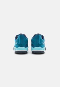 Le scarpe sportive blu e verde acqua presentano una tomaia in rete, una gola imbottita e una suola in gomma texturizzata con un intersuola bianca e accenti angolari.