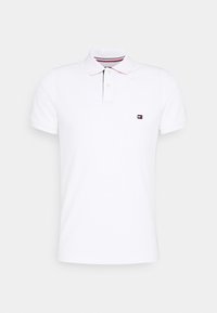 Bílá polo košile z bavlny. Krátké rukávy, límeček se dvěma knoflíky, s malým logem na levé části hrudi. Jednoduchý design.