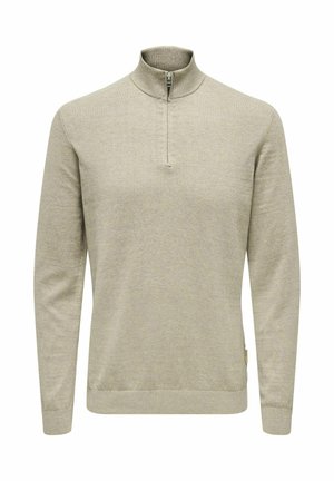 Pullover beige clair avec un col montant, doté d'une fermeture éclair sur le devant et de poignets et d'un ourlet côtelés. Texture en tricot douce.