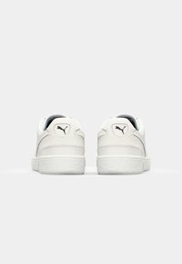 Hvite lær sneakers med teksturerte såler og subtil Puma-logo. Rund tå og polstrede ankler. Glatt finish med sydde detaljer.
