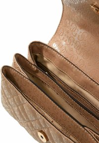 Portefeuille en cuir matelassé de couleur beige avec trois compartiments, motif de logo en relief et fermeture à bouton doré. Doublure intérieure lisse.