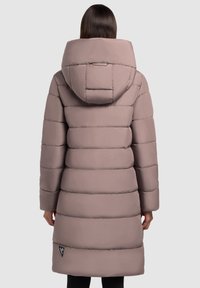 Pufferjas in licht mauve, met een capuchon en een horizontaal geborduurd ontwerp. Bevat een logo patch nabij de zoom voor extra detail.