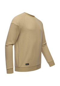 Suéter beige con una tela texturada, mangas largas, cuello redondo y puños ydo hem ribeteados. Presenta una pequeña etiqueta de marca en el lado inferior izquierdo.